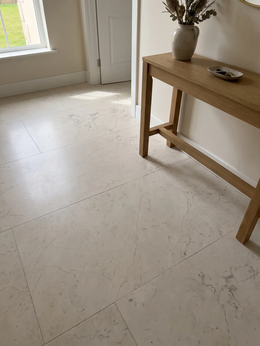 Entryway floor in large Bianco Perlino marble slabs with natural light: smooth ivory with scattered very fine thread-like gray veins