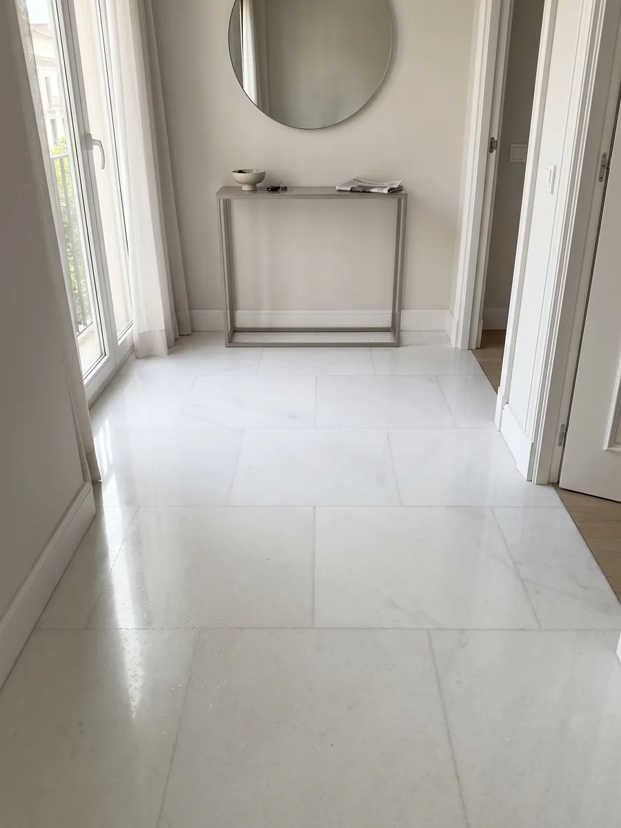 Entryway floor in large slabs of Pure White marble with natural light: uniform pure white, no visible veins or stains