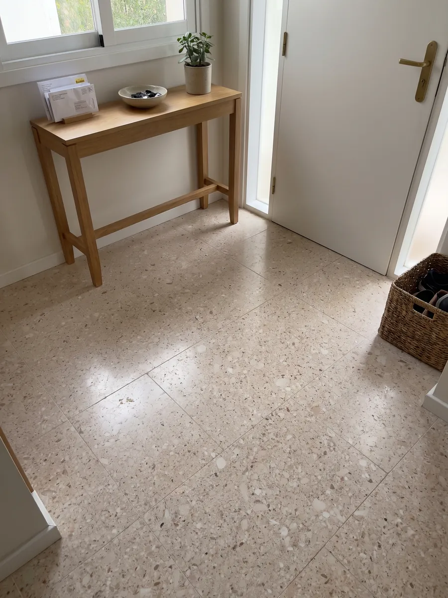 Entryway floor in large Bianco Romano marble slabs with natural light: pinkish beige speckled with small rounded white and brown clasts