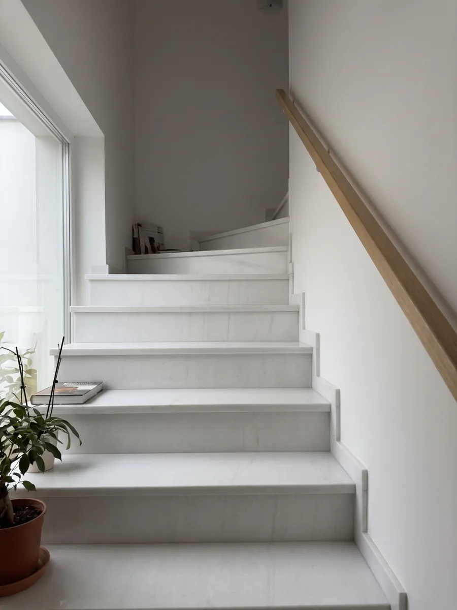 Interior staircase with Bianco Sivec marble steps and a handrail: a very pure, even white with practically no pattern