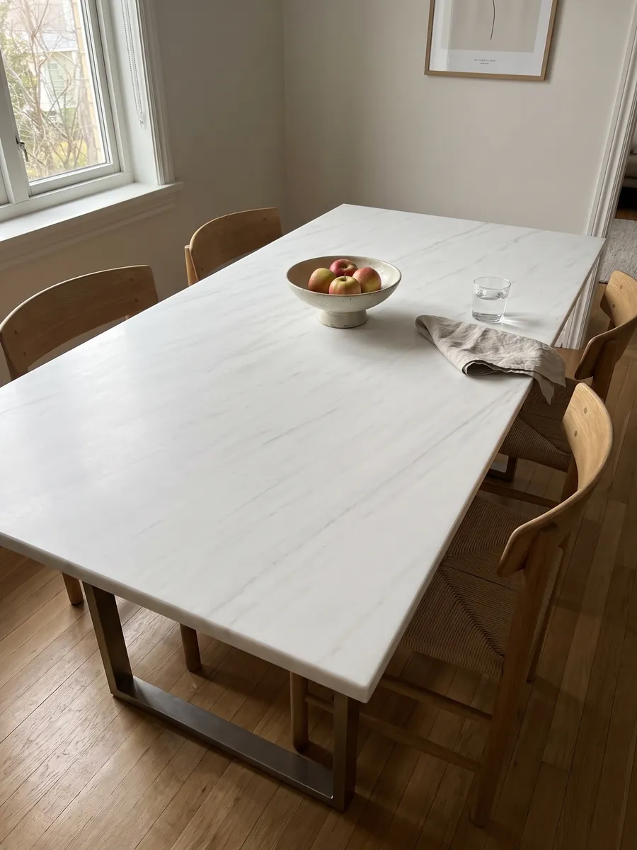Dining table with a Snow White marble top on a steel base: a very clean white with barely visible gray traces running diagonally