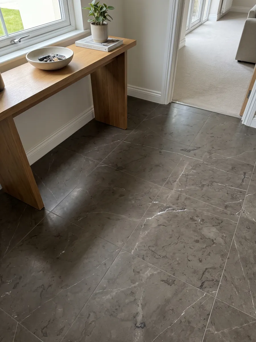 Foyer floor in large brown Grafite marble slabs in natural light: dark background between brown and graphite with a few very fine white veins