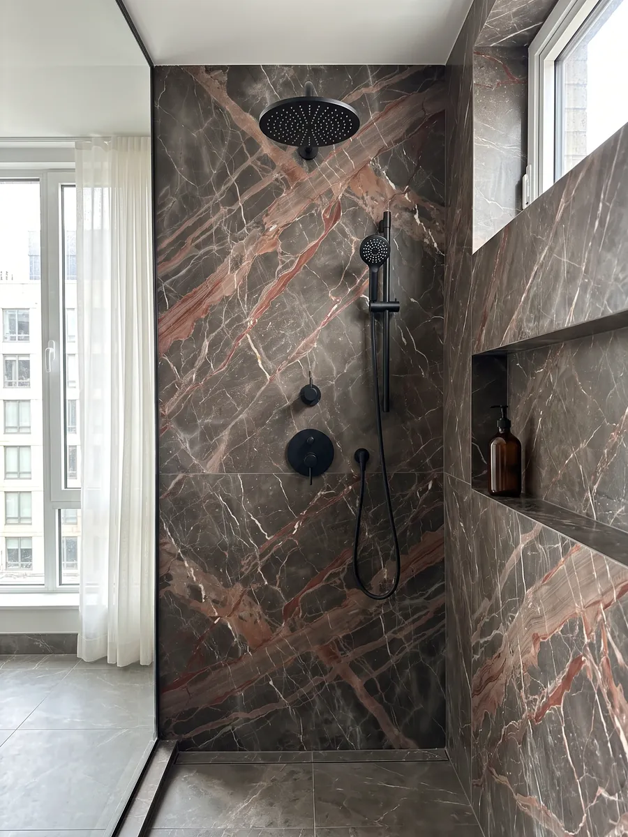 Shower clad in full brown Ombra di Caravaggio marble slabs with a recessed niche: dark gray-brown crossed by wide terracotta veins and fine white veins