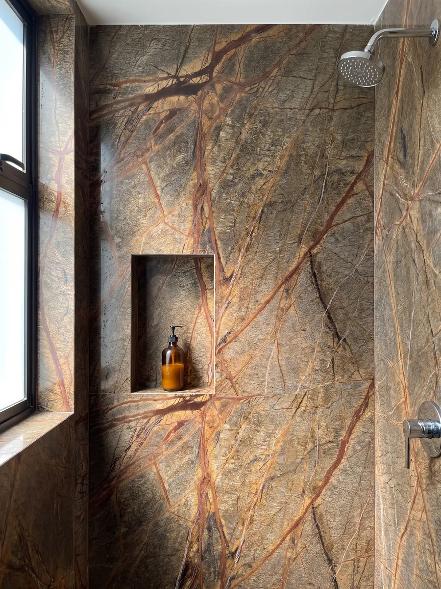 Shower clad in full Picasso Brown marble slabs with a recessed niche: olive brown crossed by a net of rust-red veins