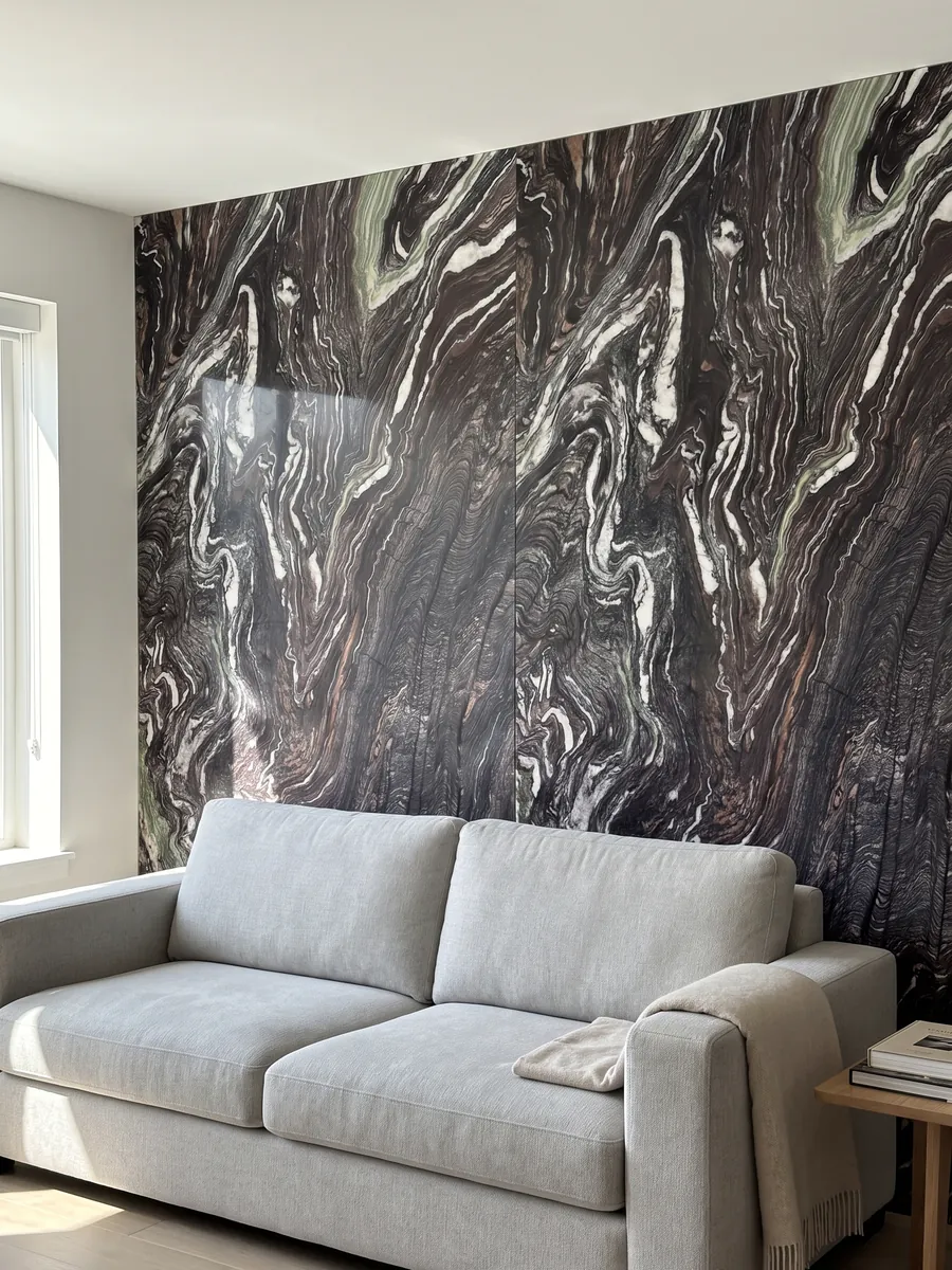 Living room wall clad in bookmatched Cipollino Ondulato marble slabs behind a sofa: deep purple background with strongly wavy, folded white veins