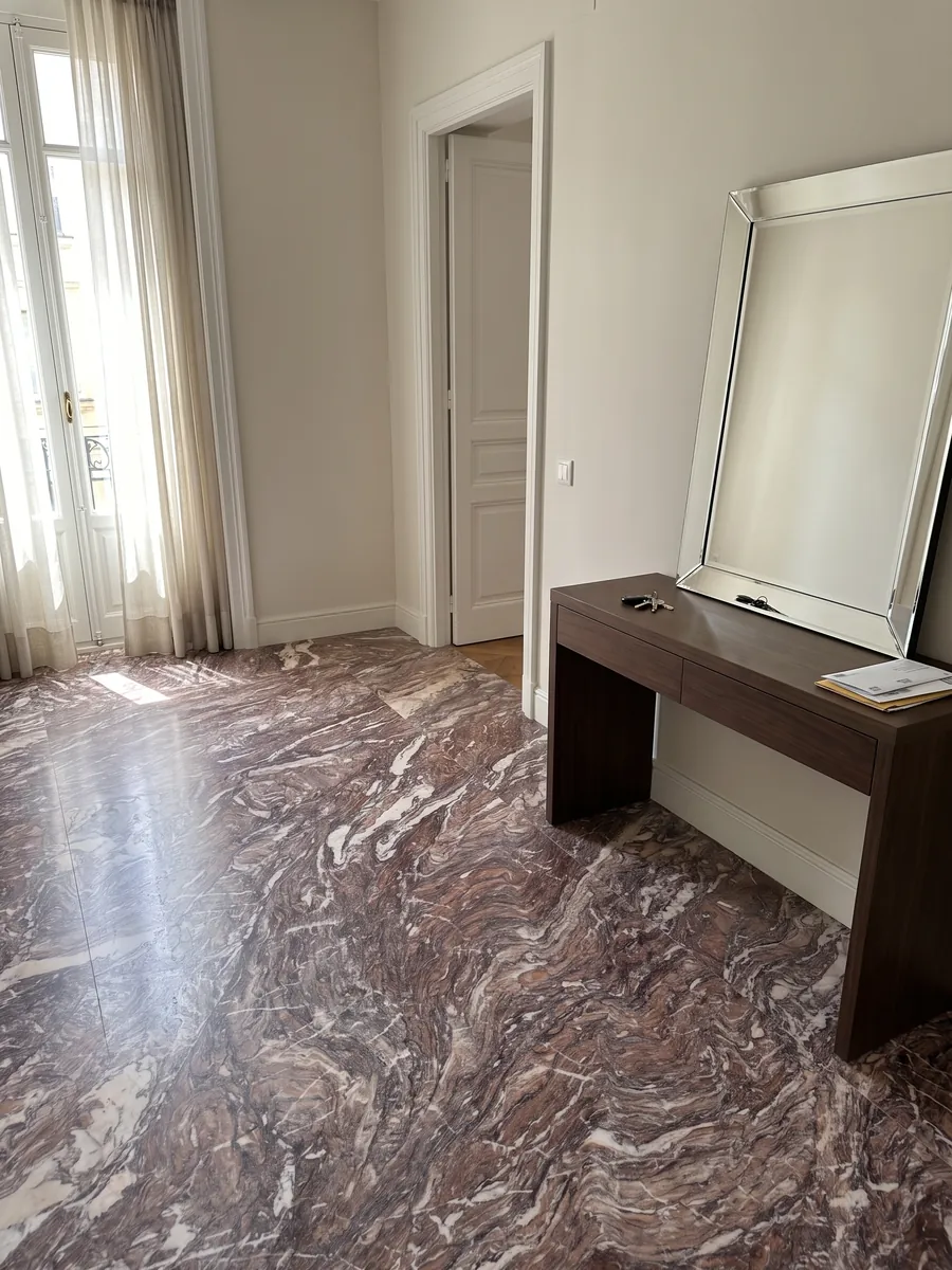 Entryway floor in large Cipollino Viola marble slabs with natural light: reddish violet with dense fine folds and some white veins
