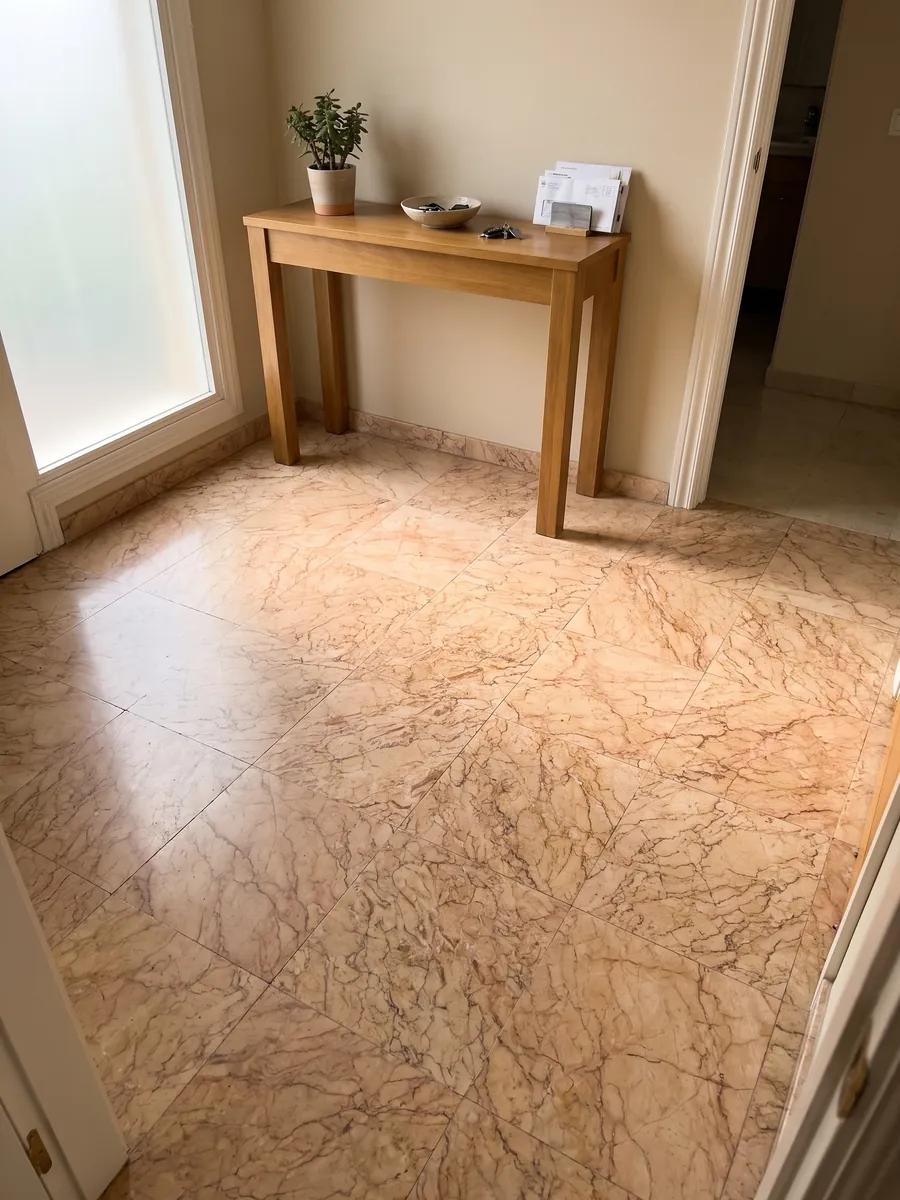 Foyer floor in large Crema Valencia marble slabs with natural light: pinkish salmon with a dense web of fine brown veins