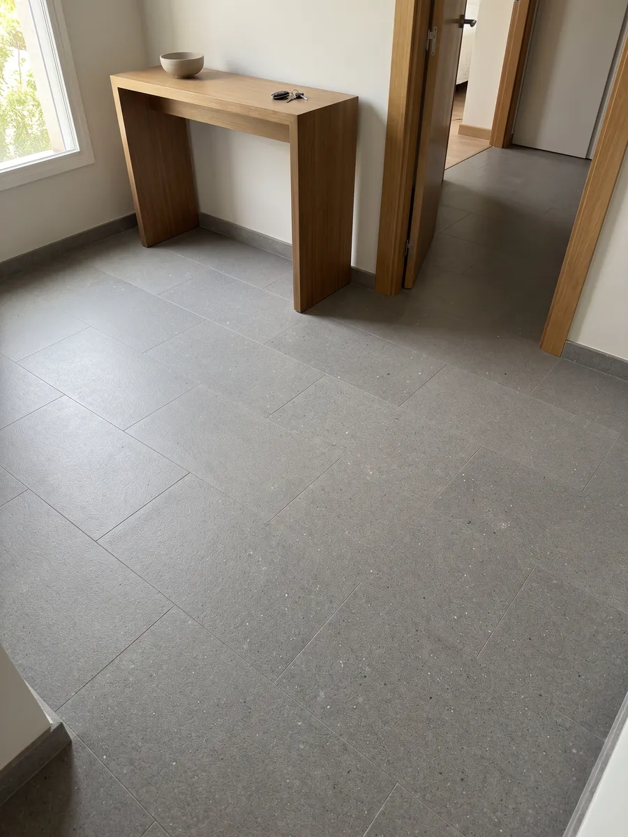 Kitchen island with a Grigio Aitos marble countertop and a straight edge in a kitchen with natural light: medium gray, fine grained, evenly speckled, no veins