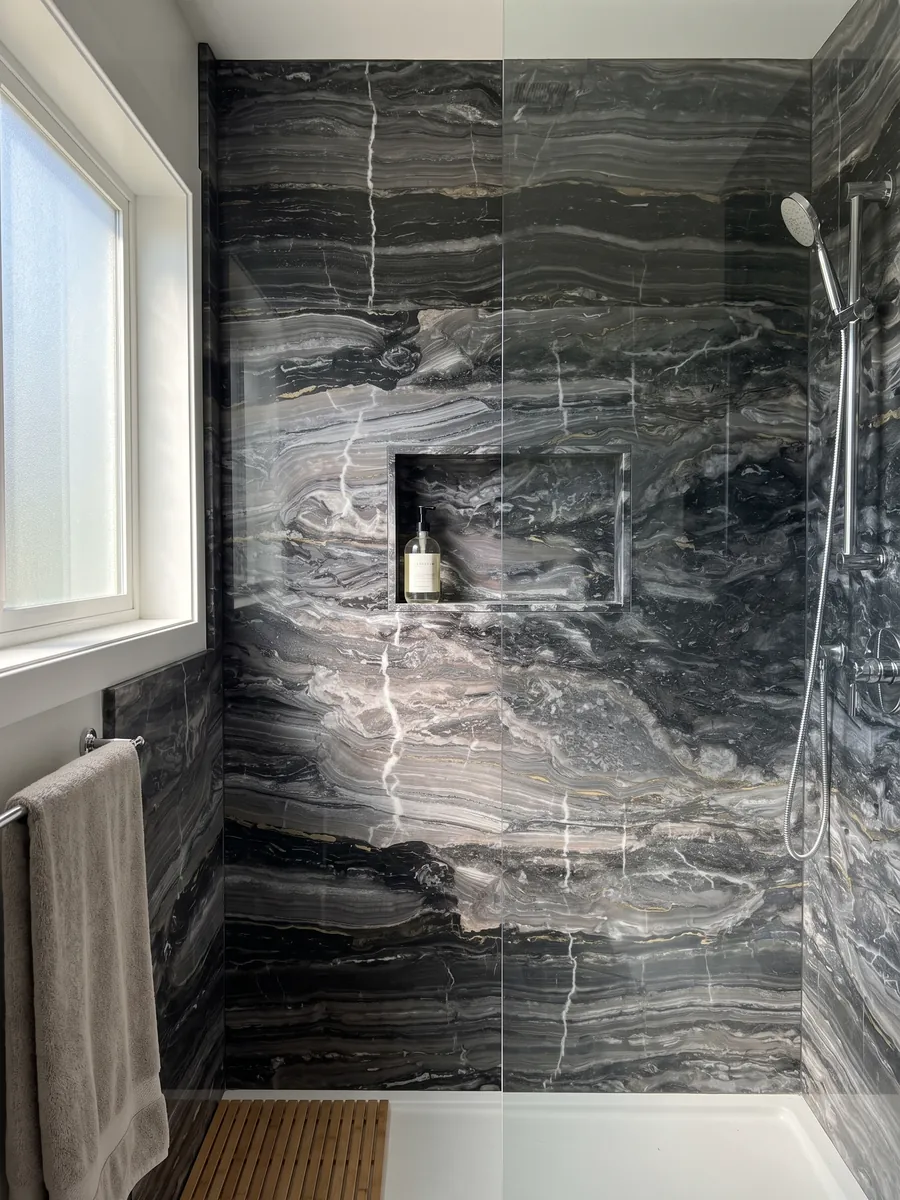Shower clad in full gray Arabescato Grigio Orobico marble slabs with a recessed niche: anthracite gray with horizontal waves and a few fine white veins crossing it vertically