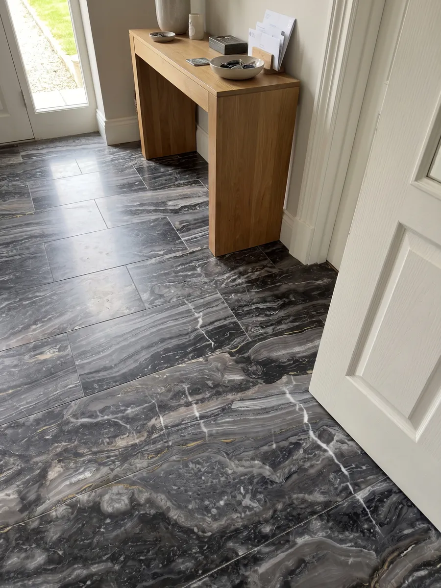 Entryway floor in large gray Arabescato Grigio Orobico marble slabs with natural light: anthracite gray with horizontal waves and a few fine white veins crossing it vertically