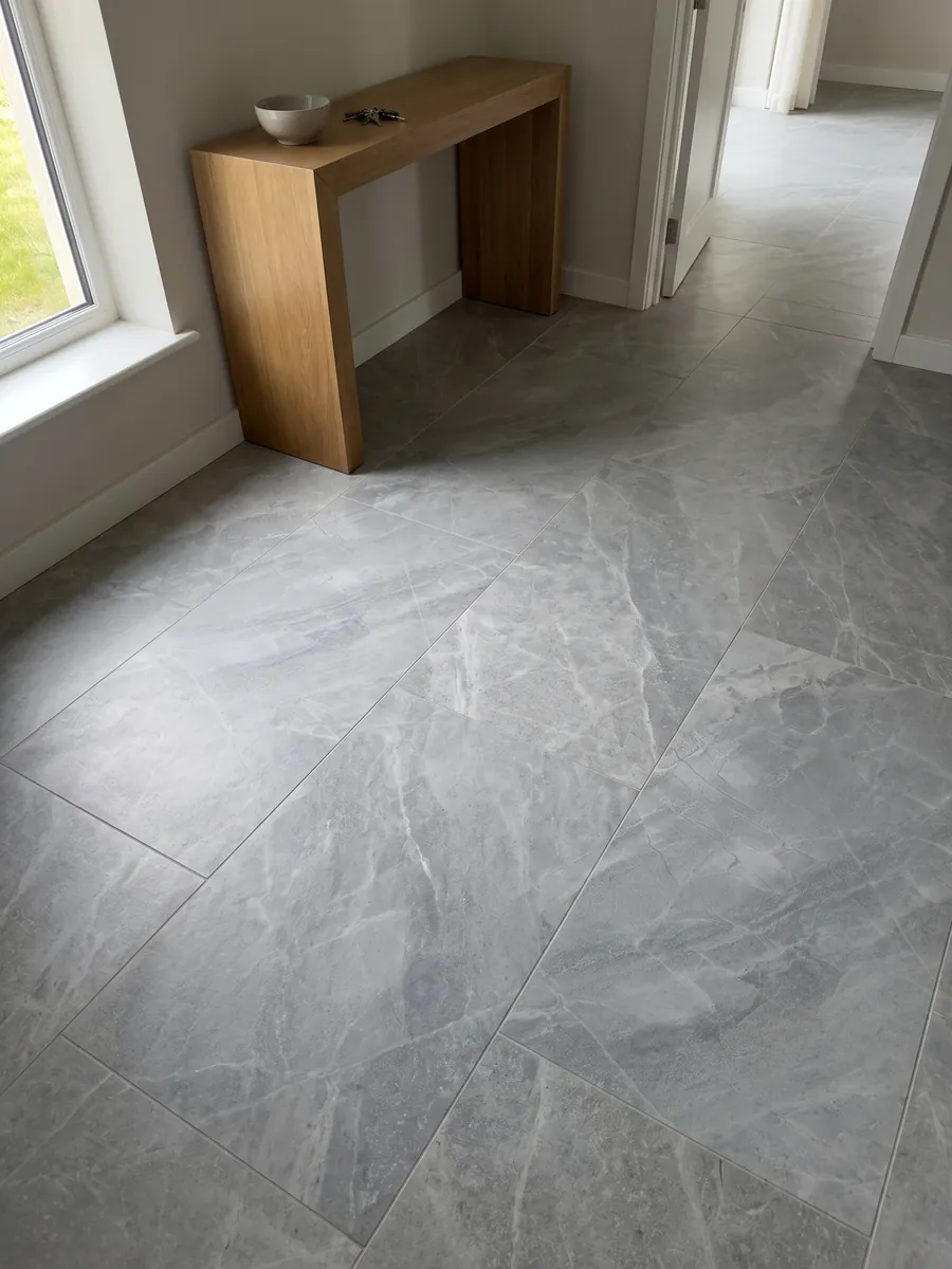 Entryway floor in large slabs of gray Bleu de Savoie marble with natural light: blue-gray with a fine web of light veins and lighter clouds