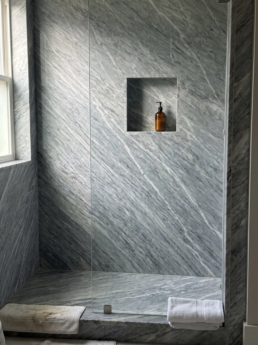 Shower clad in full gray Calacatta Bluette marble slabs with a recessed niche: bluish gray with very dense fine white and gray diagonal strokes