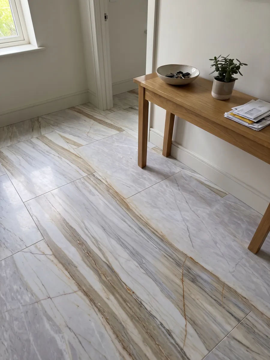 Entryway floor in large slabs of gray Calacatta Supreme marble with natural light: light lavender gray with diagonal beige bands and fine ocher lines