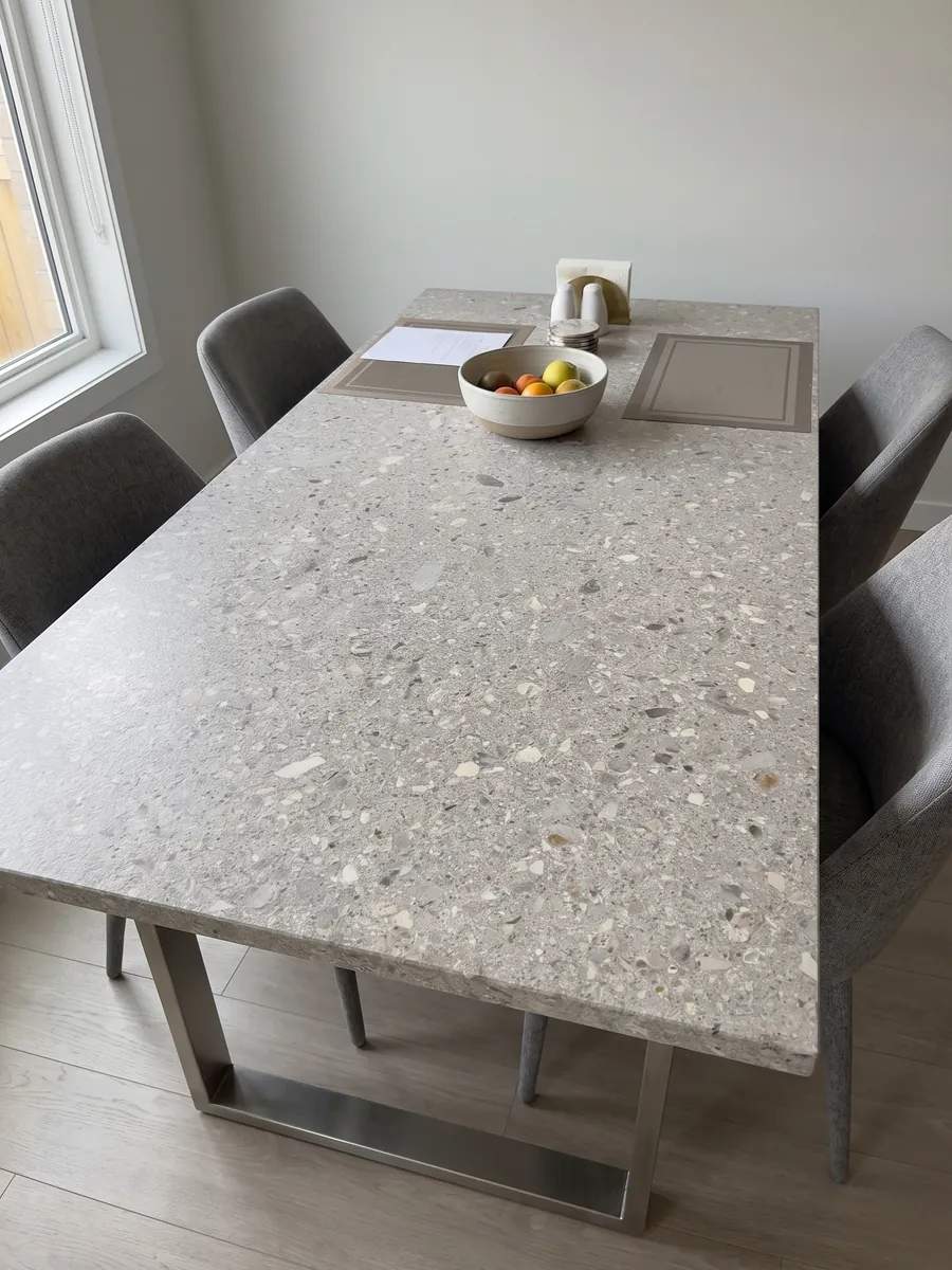 Dining table with a gray Ceppo di Gré marble top on a steel base: light gray with small beige and gray fragments spread across it