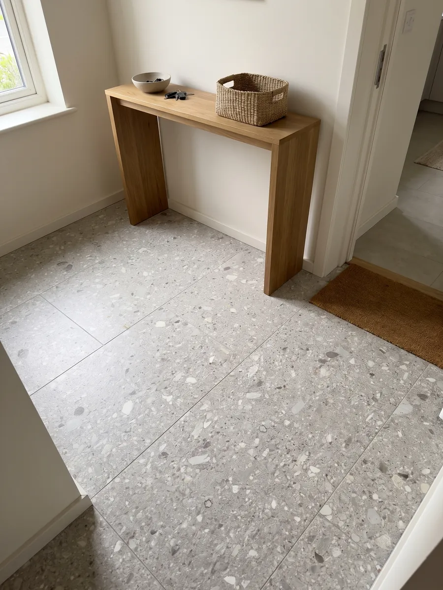 Entryway floor in large slabs of gray Ceppo di Gré marble with natural light: light gray with small beige and gray fragments spread across it