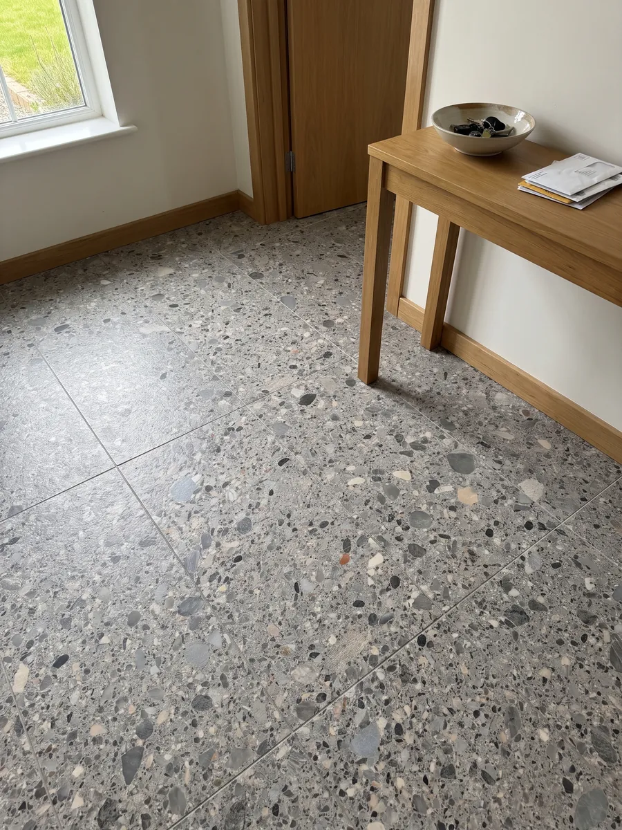 Entryway floor in large slabs of gray Ceppo marble with natural light: gray matrix with gray, beige and black pebbles of various sizes