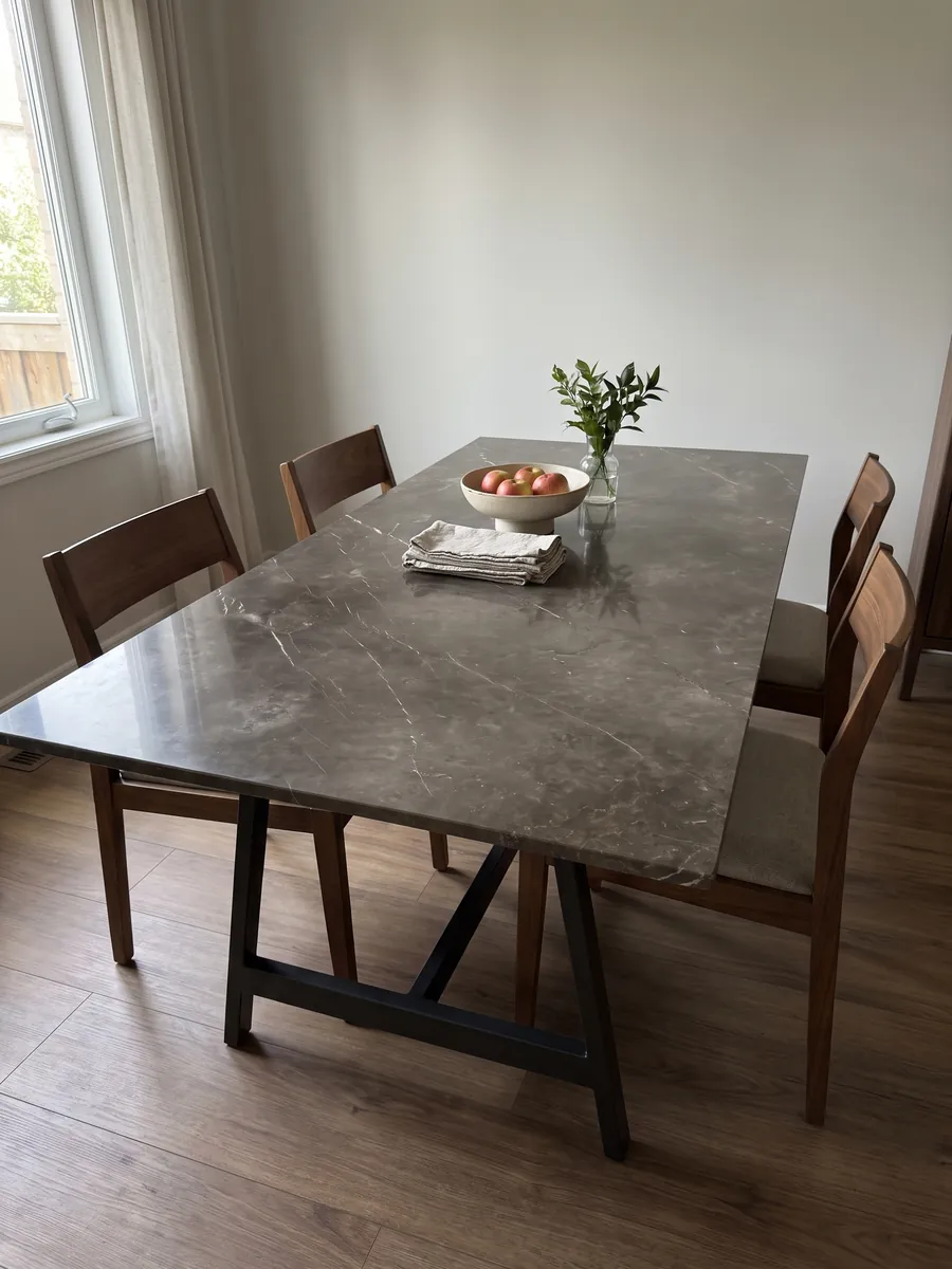 Dining table with a Grigio Collemandina marble top on a steel base: cloudy brown-gray with few, very fine white veins