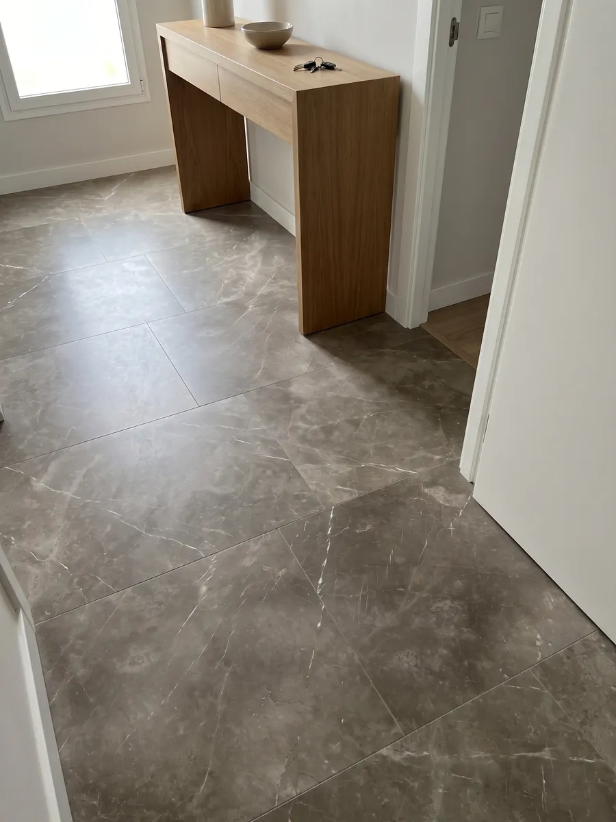 Entryway floor in large Grigio Collemandina marble slabs with natural light: cloudy brown-gray with few, very fine white veins