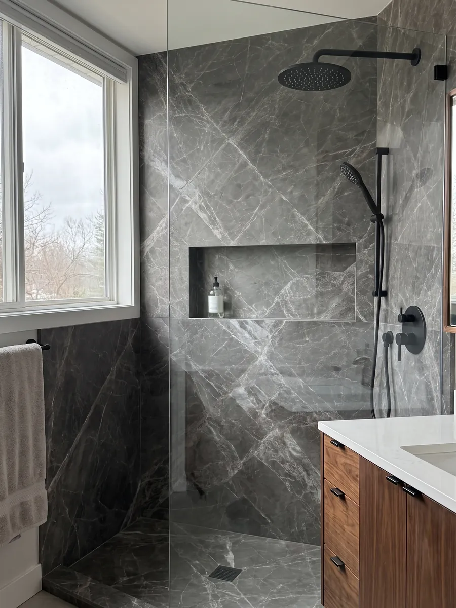 Shower clad in full Jolie Grey marble slabs with a recessed niche: dark gray with light veins crossing diagonally to form diamonds