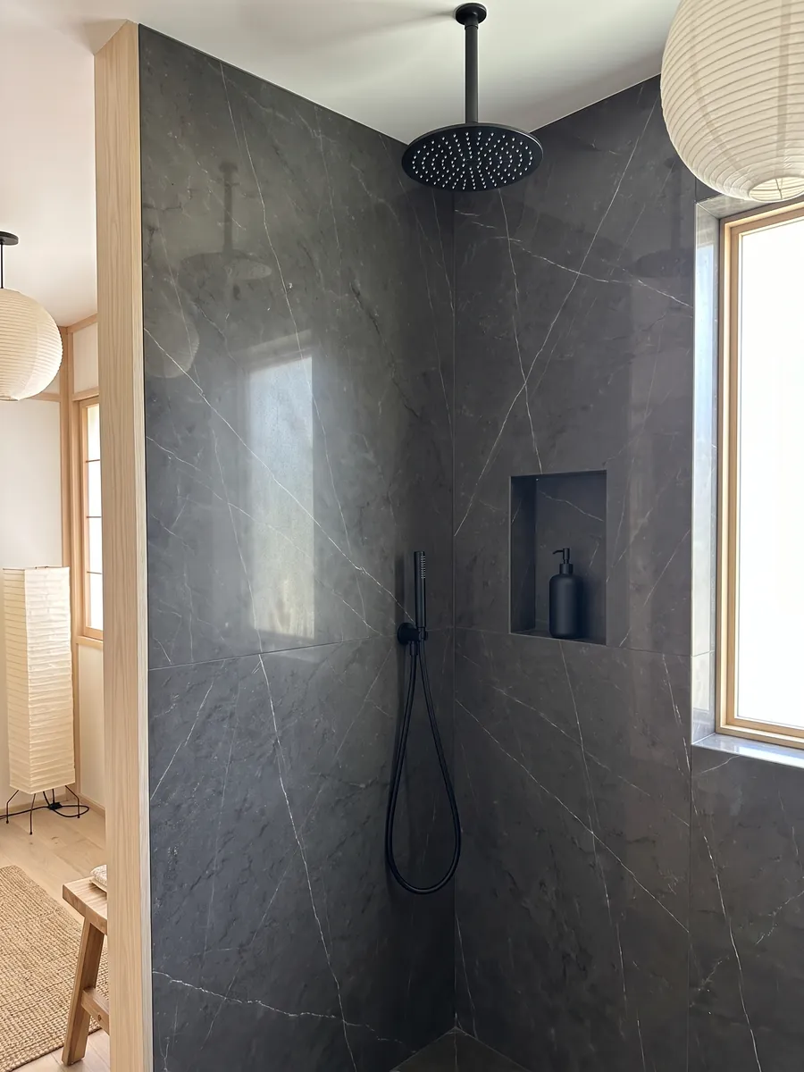 Shower clad in full gray Pietra Grey marble slabs with a recessed niche: dark gray with a few fine light gray veins