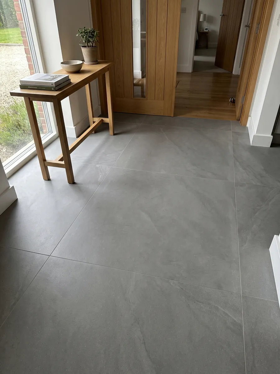 Entryway floor in large gray Pietra Serena marble slabs with natural light: smooth, even medium gray with no veins