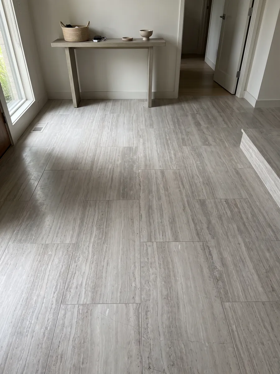 Entryway floor in large slabs of gray White Wood marble with natural light: light gray with fine horizontal lines that imitate wood grain