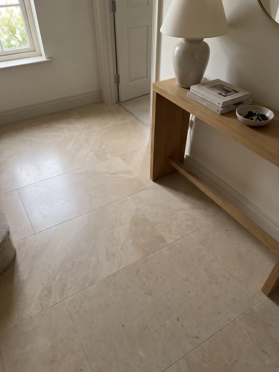 Entryway floor in large Avorio marble slabs with natural light: nearly smooth warm beige with very soft tonal variation