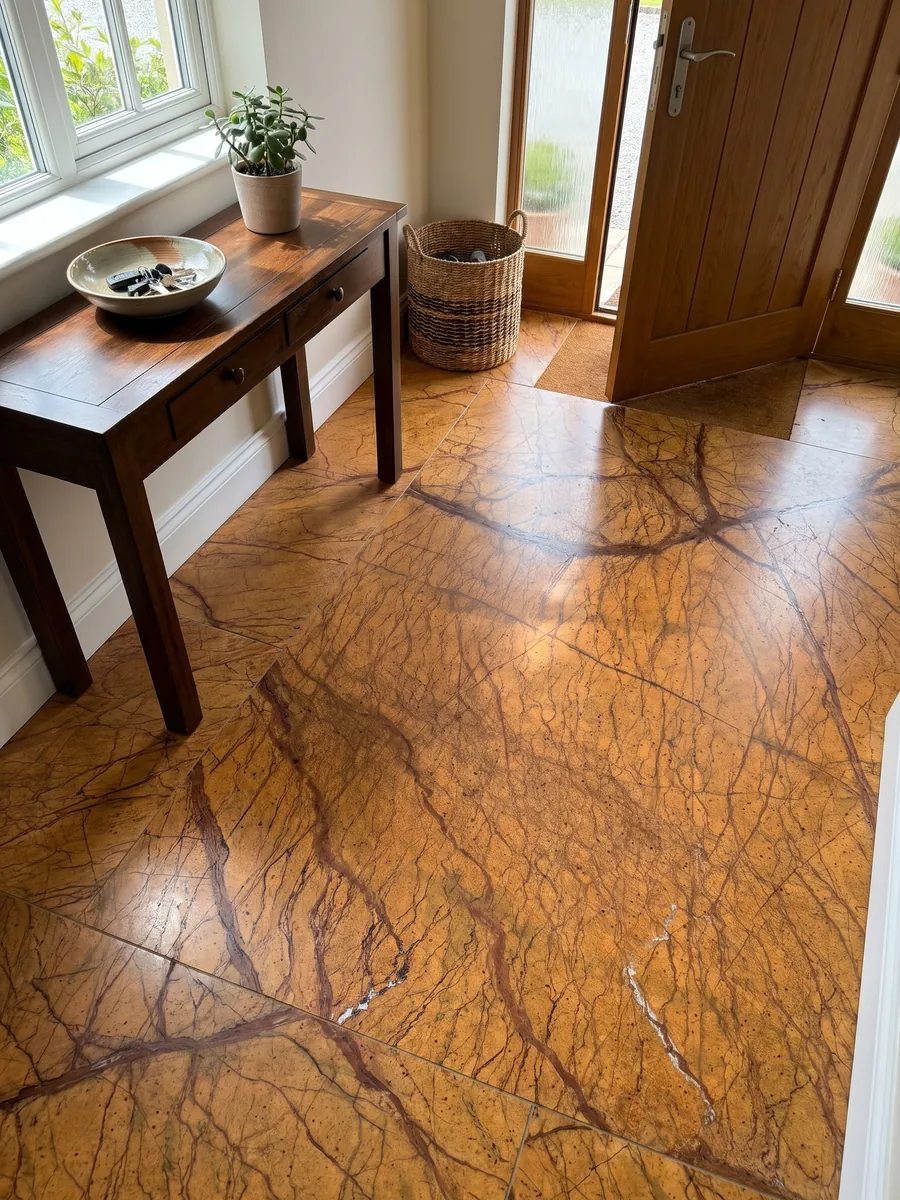 Entryway floor in large Picasso Gold marble slabs with natural light: intense ocher orange with a net of branching reddish brown veins