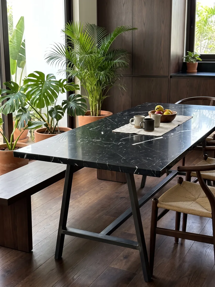 Dining table with a black Nero Marquina marble top on a steel base: deep black with a few fine straight white veins