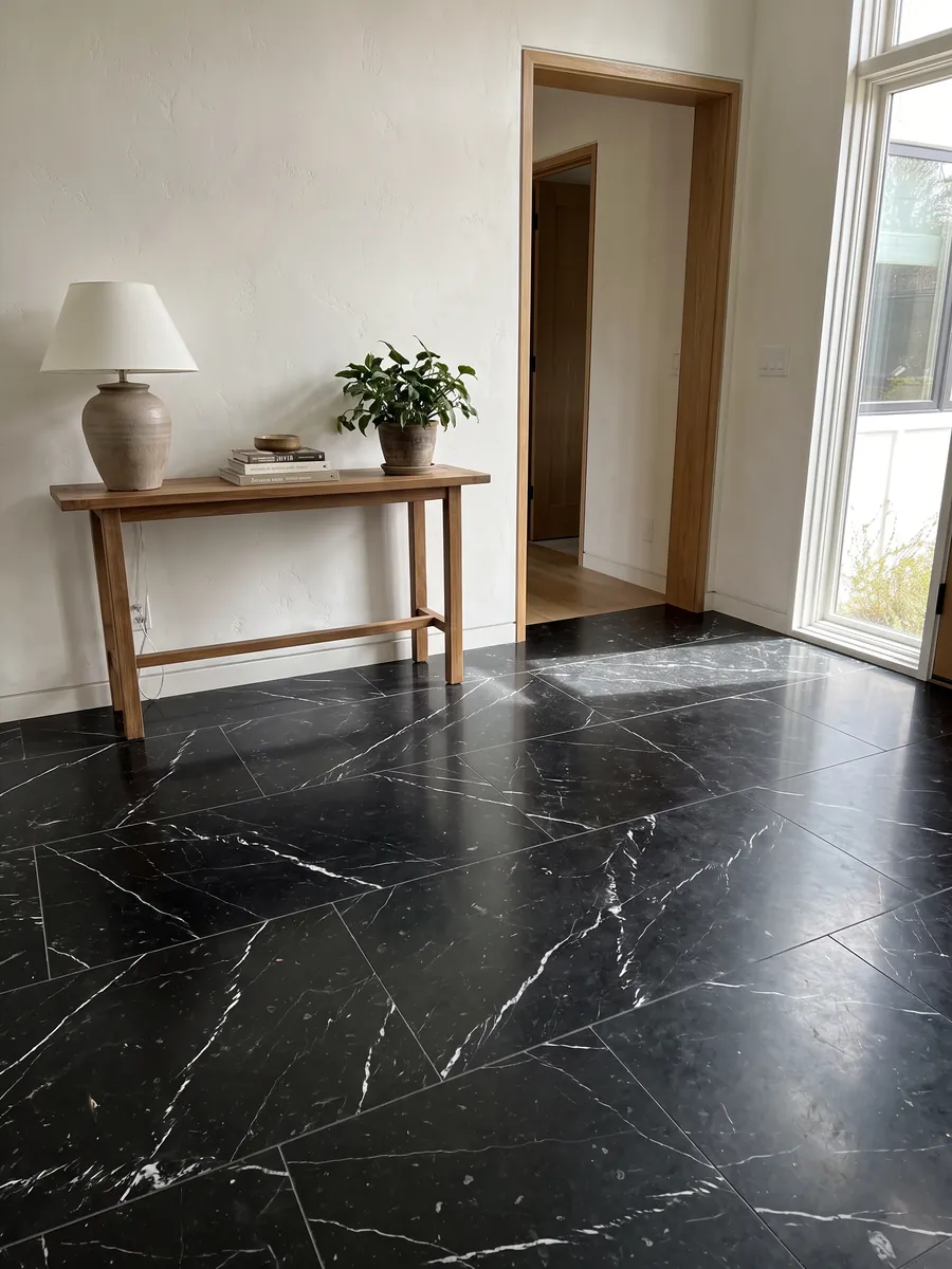 Entryway floor in large black Nero Marquina marble slabs with natural light: deep black with a few fine straight white veins