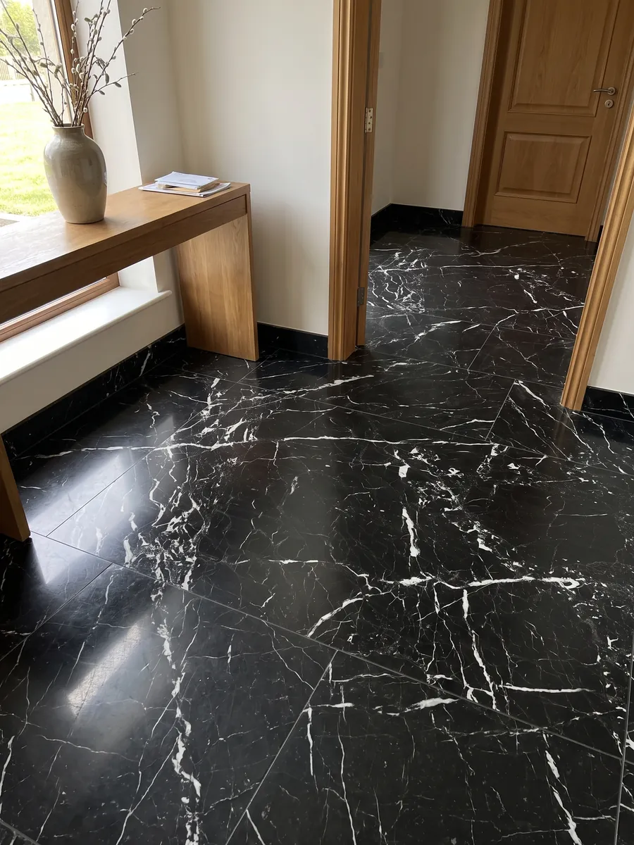 Entryway floor in large slabs of Napoleon Black marble with natural light: intense black with a crisp, irregular network of white veins