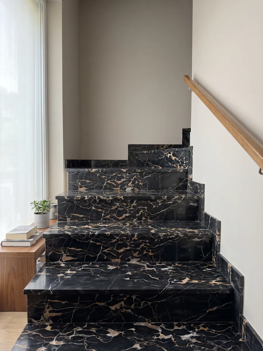 Interior staircase with Nero Portoro marble steps and a handrail: black with a dense web of gold and white veins
