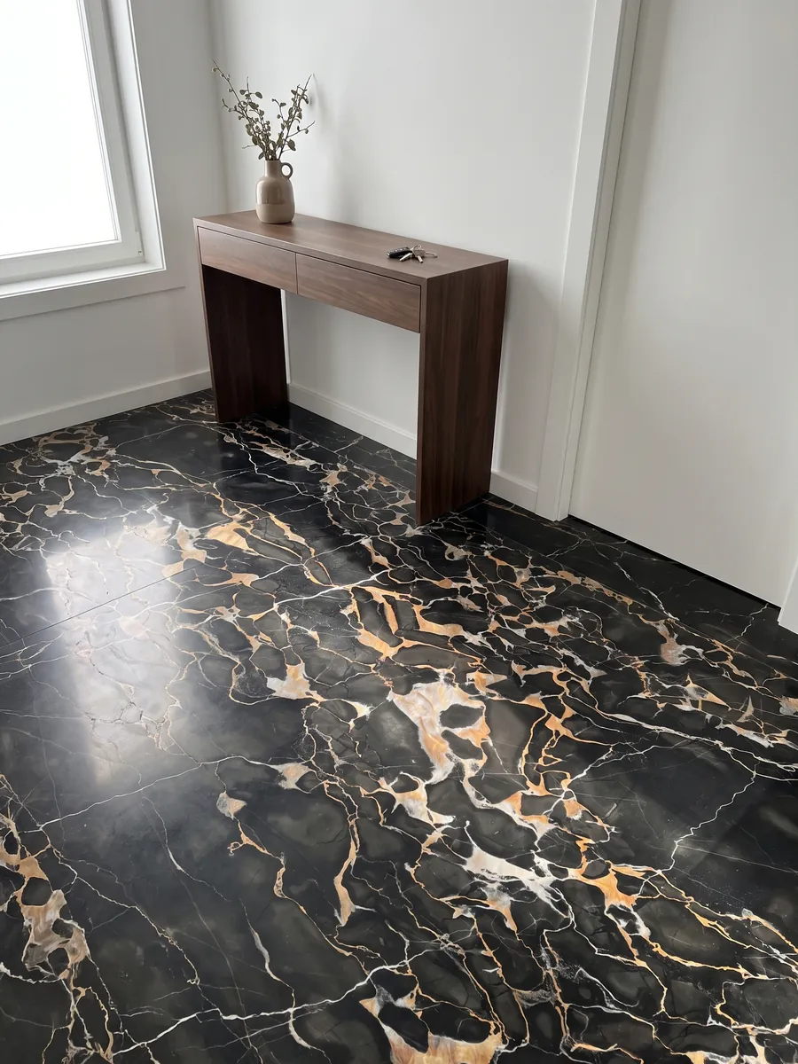 Entryway floor in large slabs of black Nero Portoro marble with natural light: black with a dense web of gold and white veins