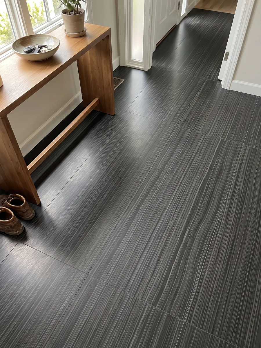 Entryway floor in large Nero Pagoda marble slabs with natural light: black with fine horizontal, parallel gray lines, almost like wood