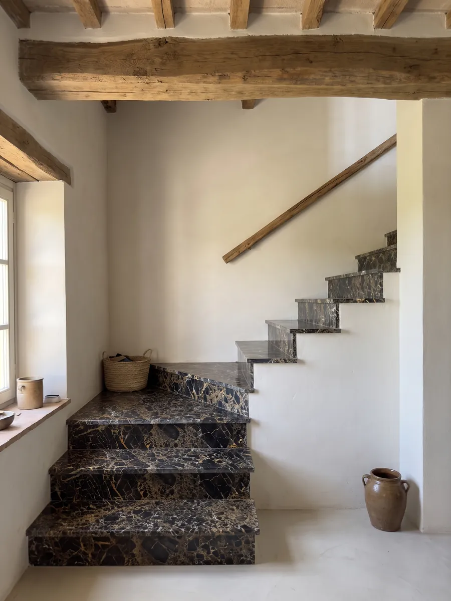 Interior staircase with black Portoro marble steps and a handrail: black fragments wrapped in a dense web of gold and white veins