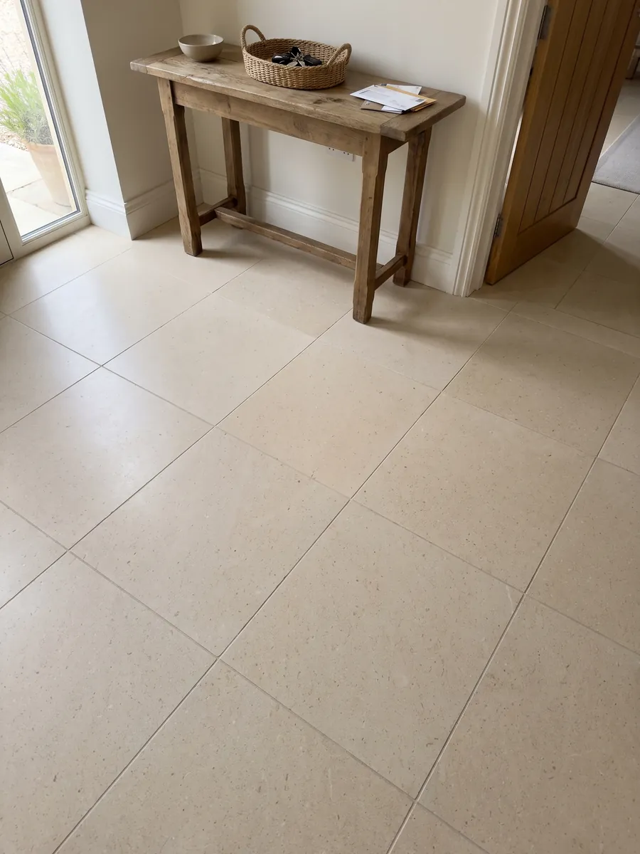 Entryway floor in large slabs of New Marfil marble with natural light: very uniform light cream, fine-grained and vein-free