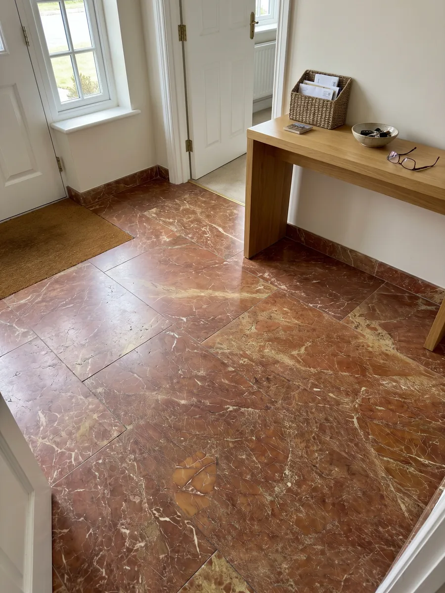 Entryway floor in large red Melograno marble slabs with natural light: brownish brick red with a fine network of light veins and ochre patches