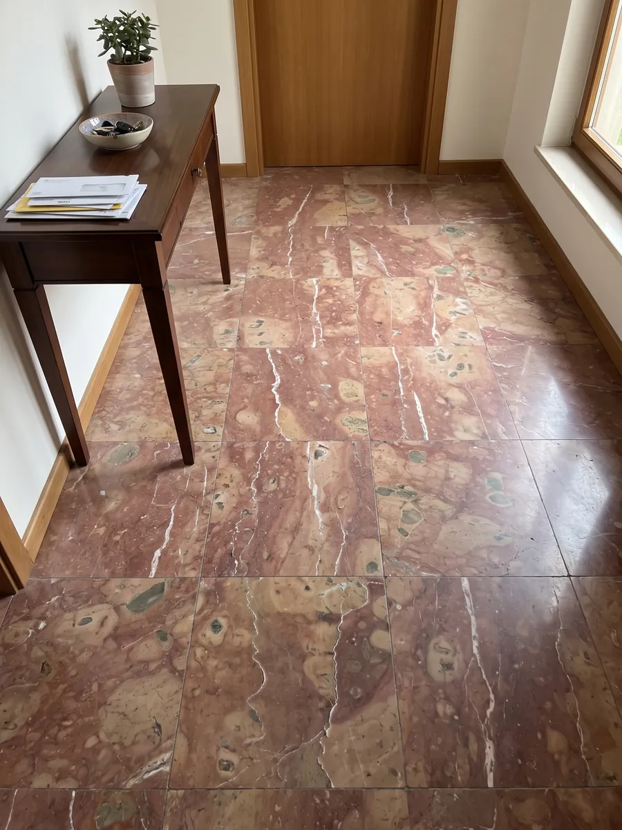 Piso de hall de entrada em placas grandes de mármore vermelho Rosso Verona com luz natural: vermelho arroxeado com manchas bege e dois veios brancos verticais irregulares