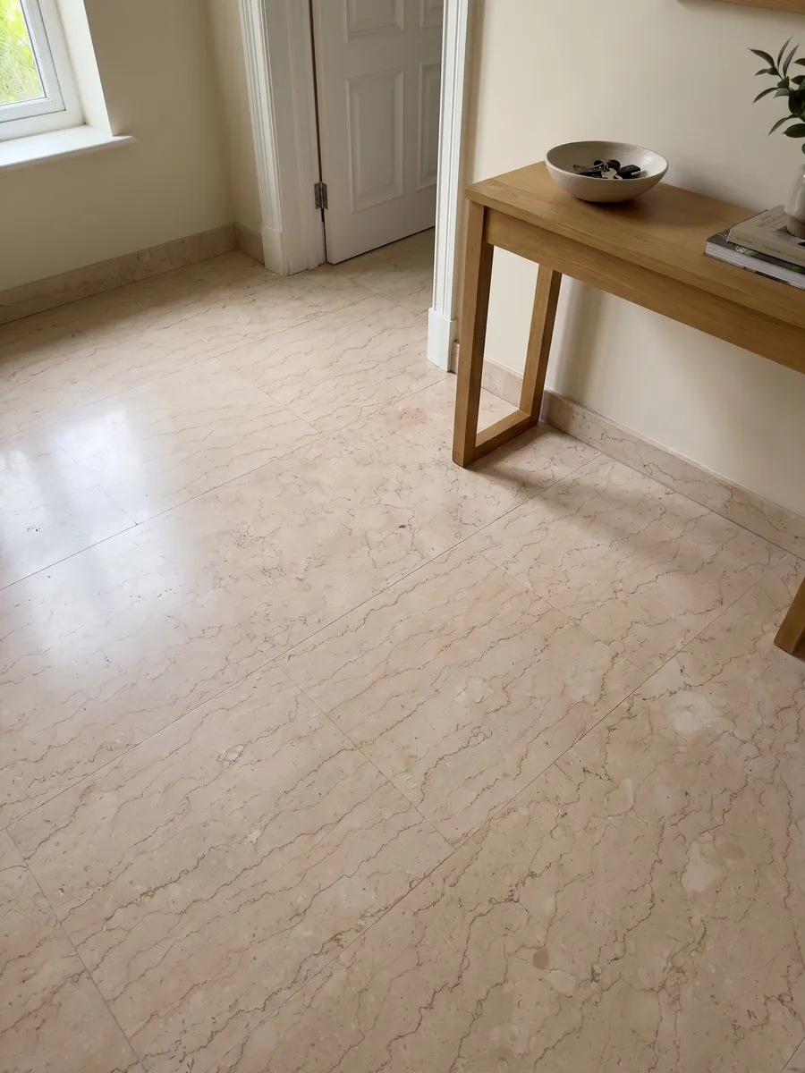 Entryway floor in large Rosa Perlino marble slabs with natural light: light pinkish beige with fine wavy lines in a soft web