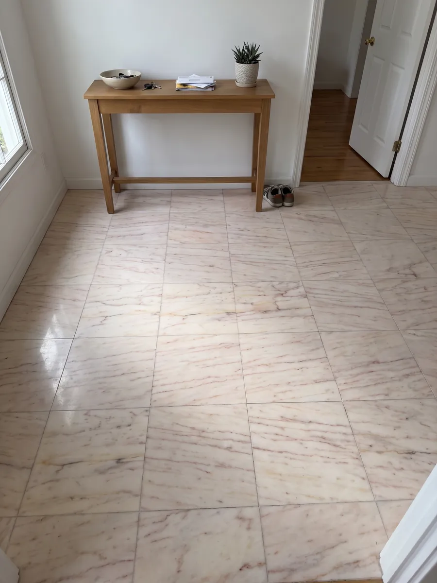Entryway floor in large Rosa Portogallo marble slabs with natural light: pale pink, almost cream, with fine reddish pink horizontal veins