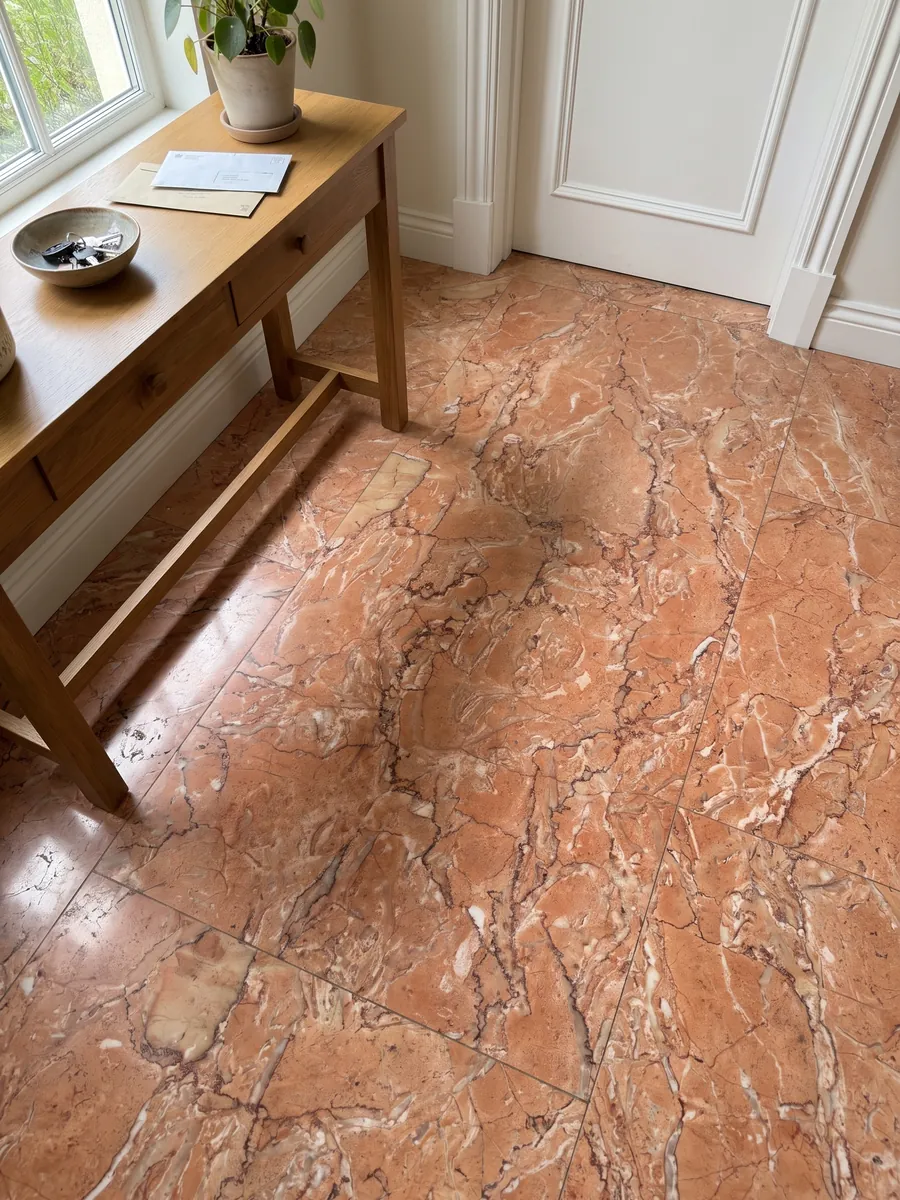 Entryway floor in large slabs of Rosa Sabrina Marble with natural light: salmon orange with a dense network of fine white and reddish veins