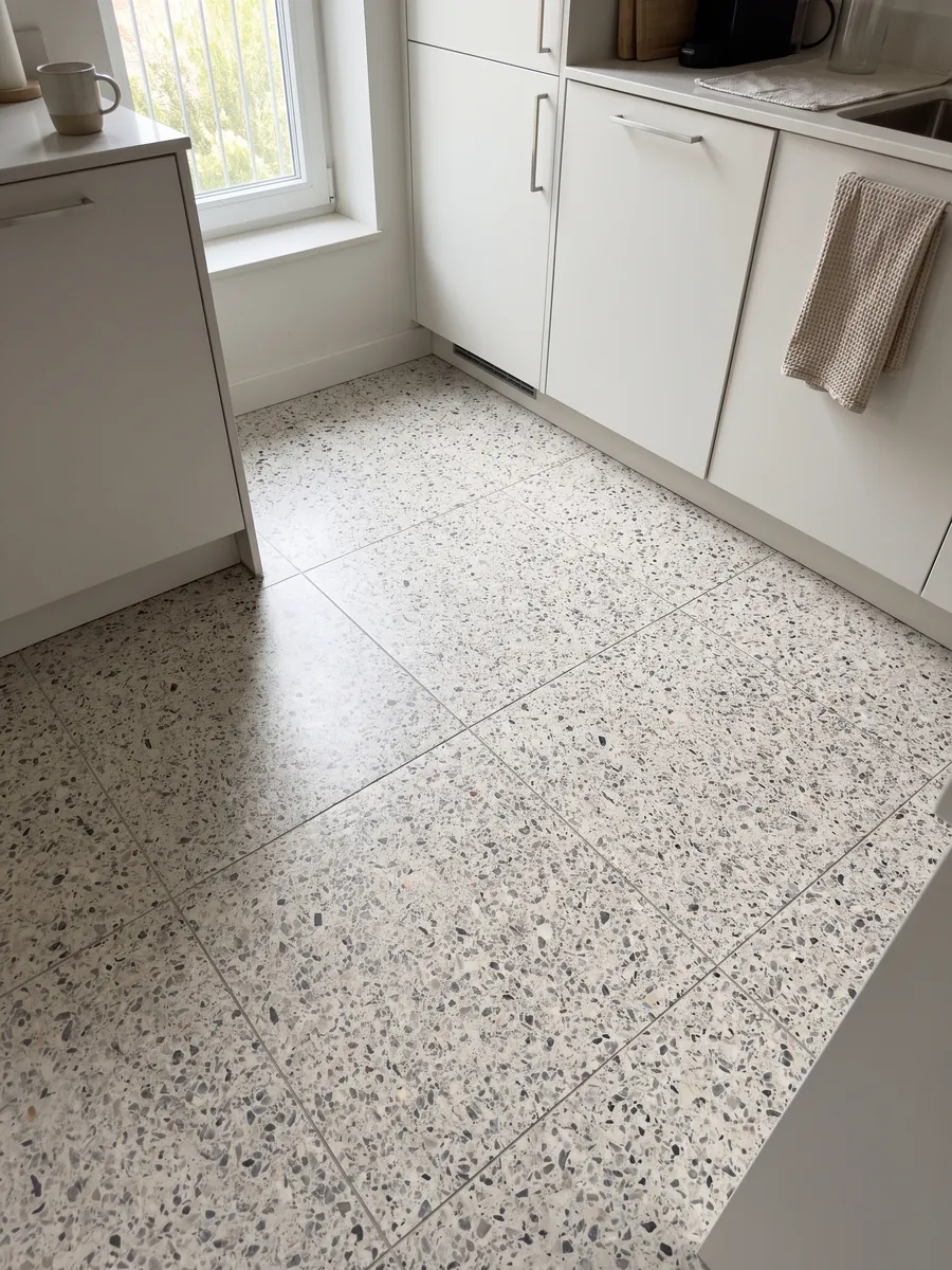 Kitchen floor in large slabs of Fior di Pesco White engineered marble with resin: ivory background with scattered gray and dark fragments, terrazzo style