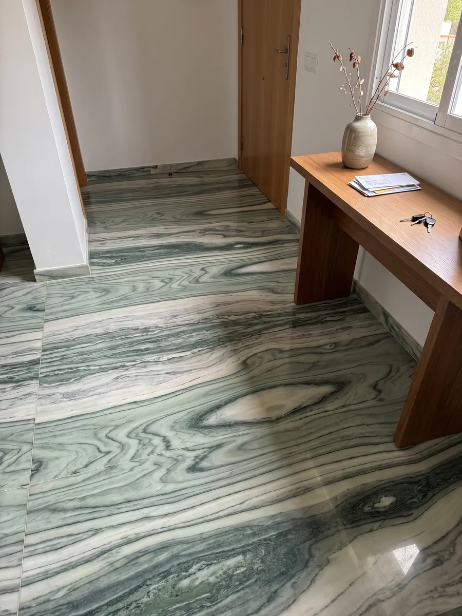 Entryway floor in large green Cipollino marble slabs with natural light: wavy dark and light green bands forming an eye shape at the center