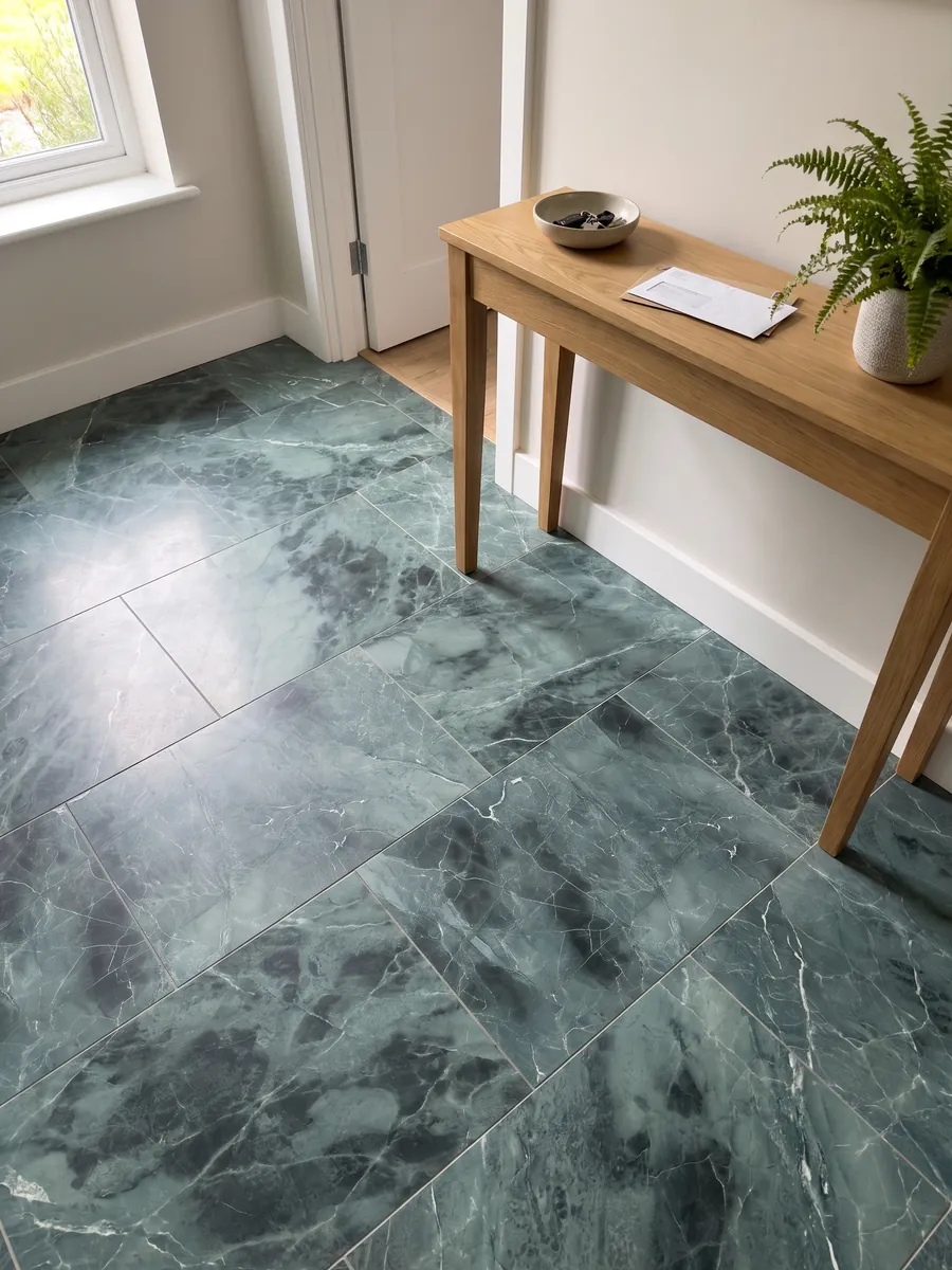 Entryway floor in large slabs of Green Algae green marble with natural light: teal with darker clouds and a network of fine white veins