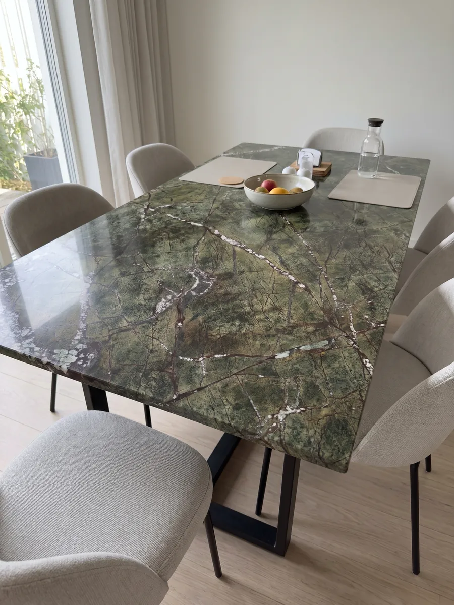 Dining table with a green Picasso Green marble top on a steel base: olive green with a network of reddish veins and white diagonal veins