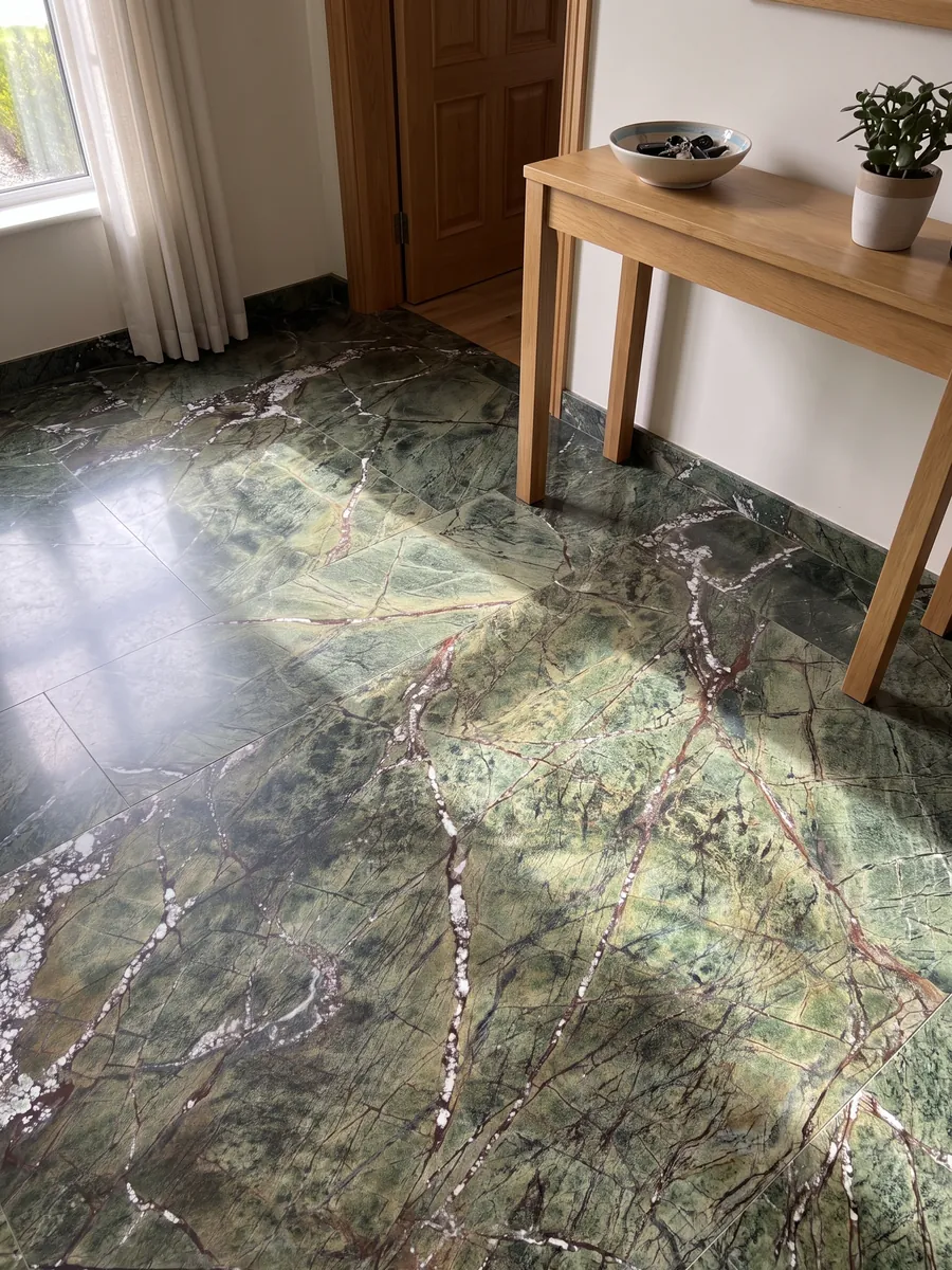 Entryway floor in large slabs of green Picasso Green marble with natural light: olive green with a network of reddish veins and white diagonal veins