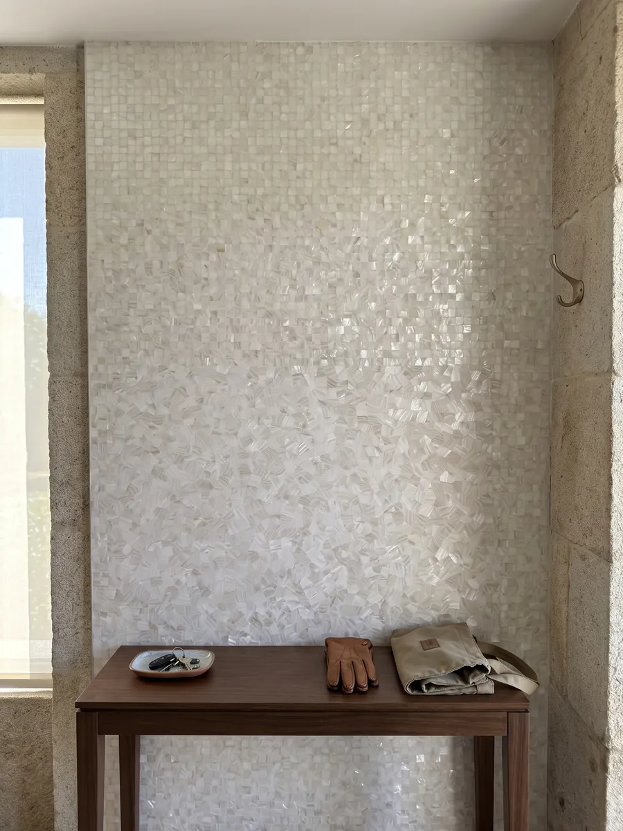 Entryway wall clad in freshwater shell mother of pearl with a narrow console: an almost uniform pearly white with very small mother-of-pearl pieces