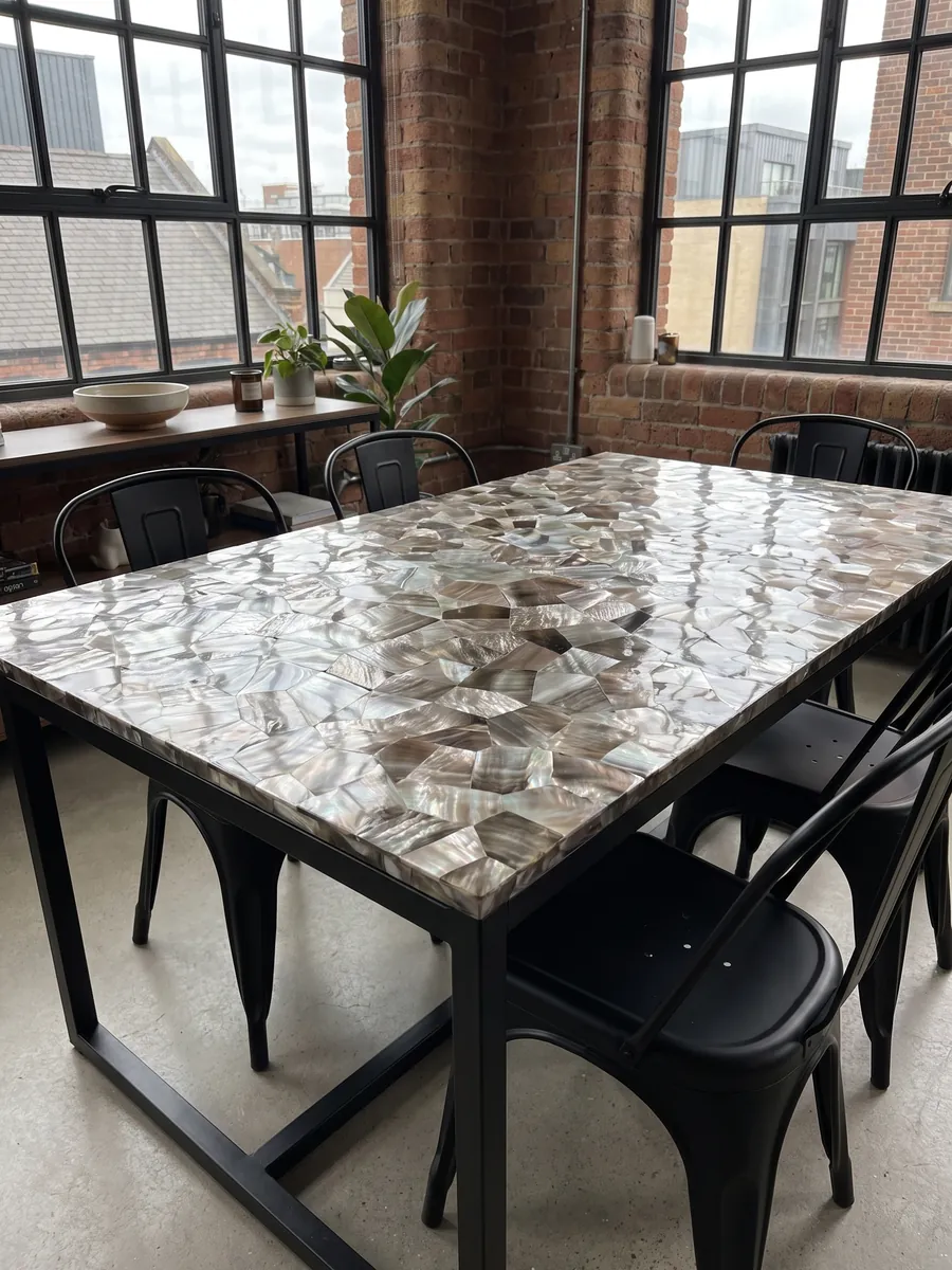 Dining table with a Brown Shell Mother of Pearl top on a steel base: pieces of taupe-gray and silvery mother of pearl with an iridescent sheen