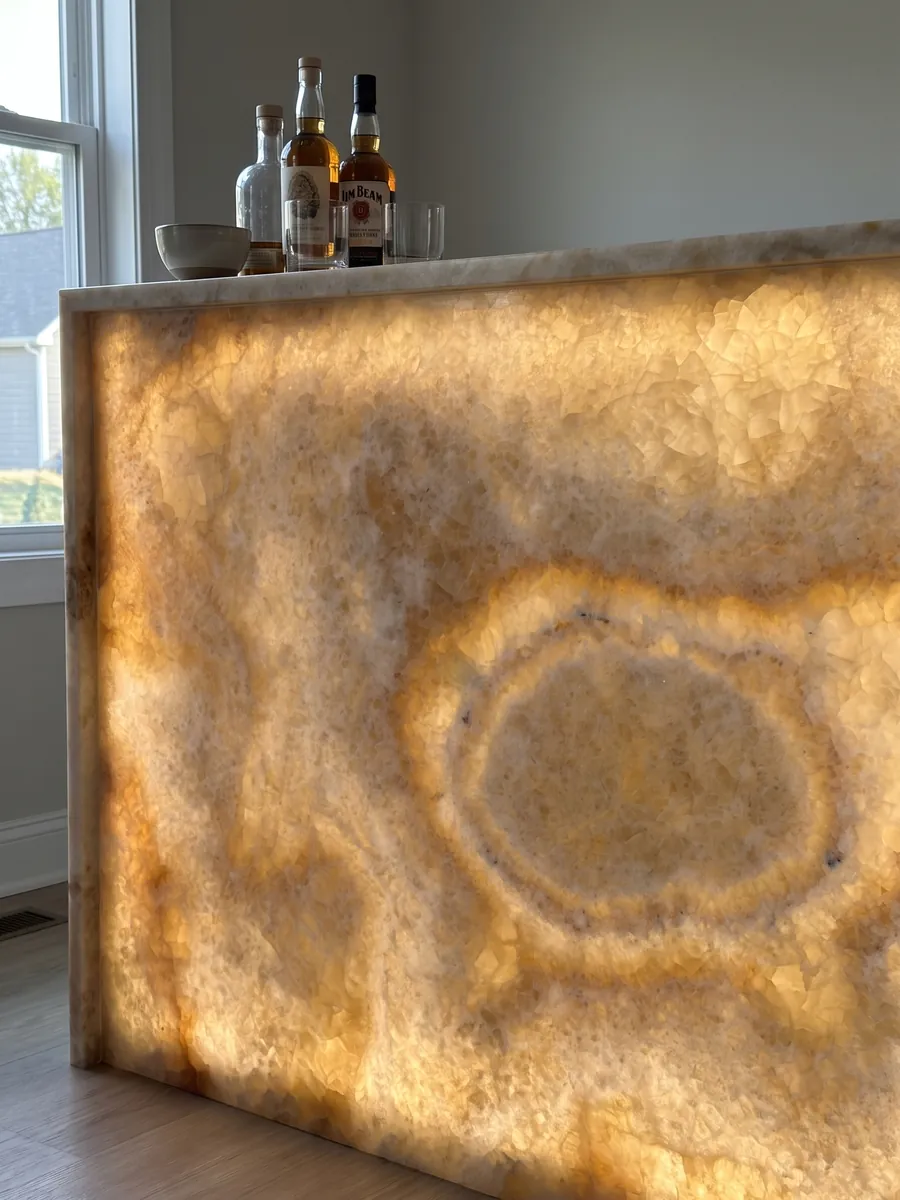 Bar with a backlit yellow onyx front, the light passing through the stone: honey and cream with a clearly visible concentric oval ring