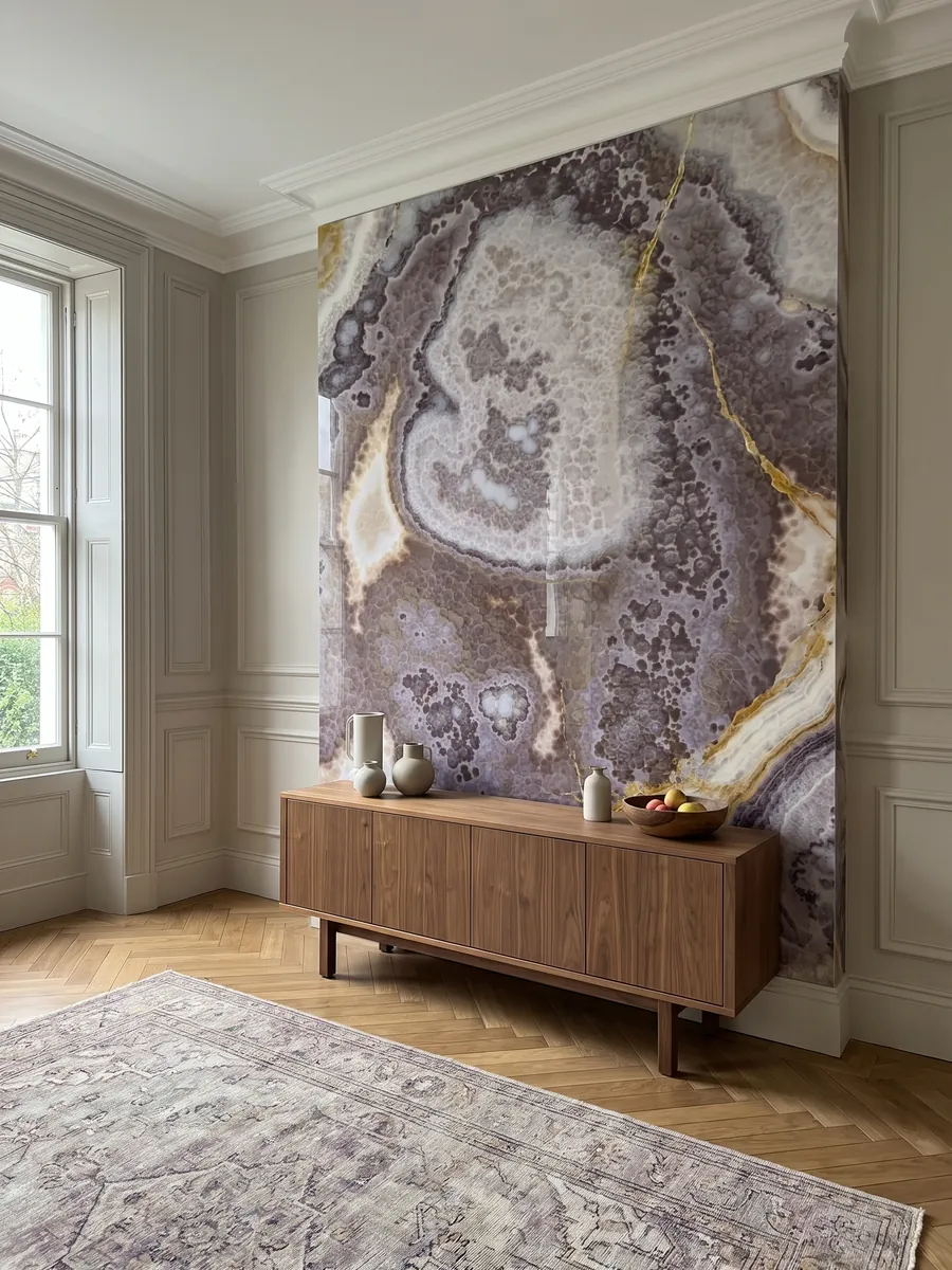 Accent wall clad in black onyx above a low wooden cabinet: it does not look black: violet with lilac and white areas and fine golden veins